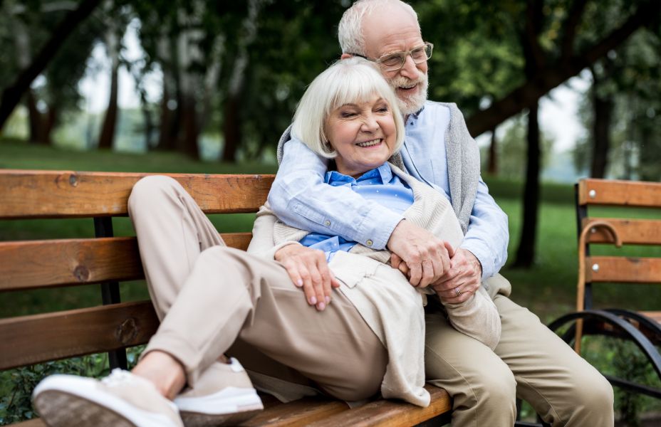 an older couple sitting on a bench in the park